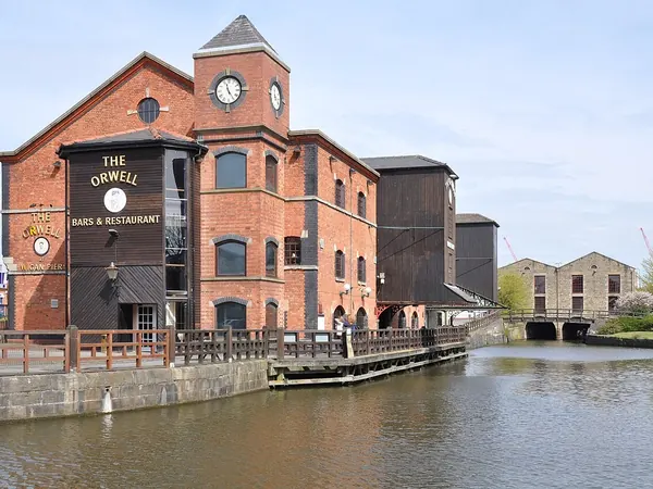 Restored canal warehouse with clock tower beside the Leeds and Liverpool Canal at Wigan Pier