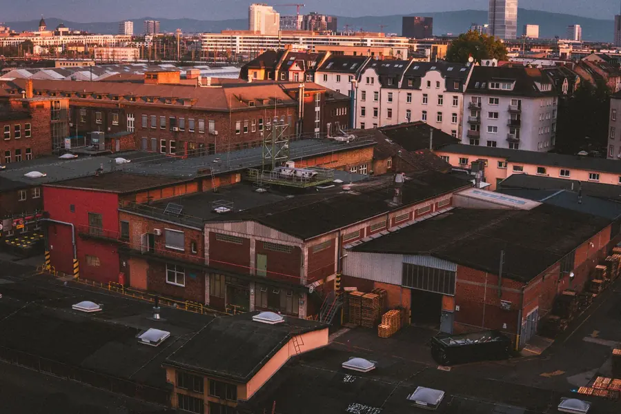 Brick industrial buildings and warehouse roofs at dusk, when weekday red-band electricity charges apply in Manchester