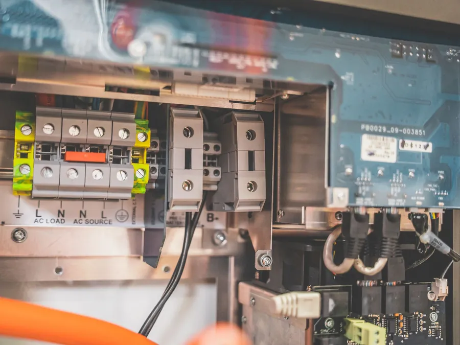 Opened solar inverter enclosure showing the isolator, terminals and cable connections during an inspection