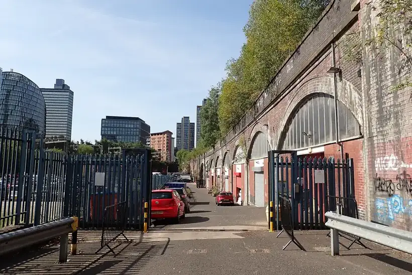 Railway arch units on Back Red Bank, Cheetham, with the Manchester city centre skyline behind
