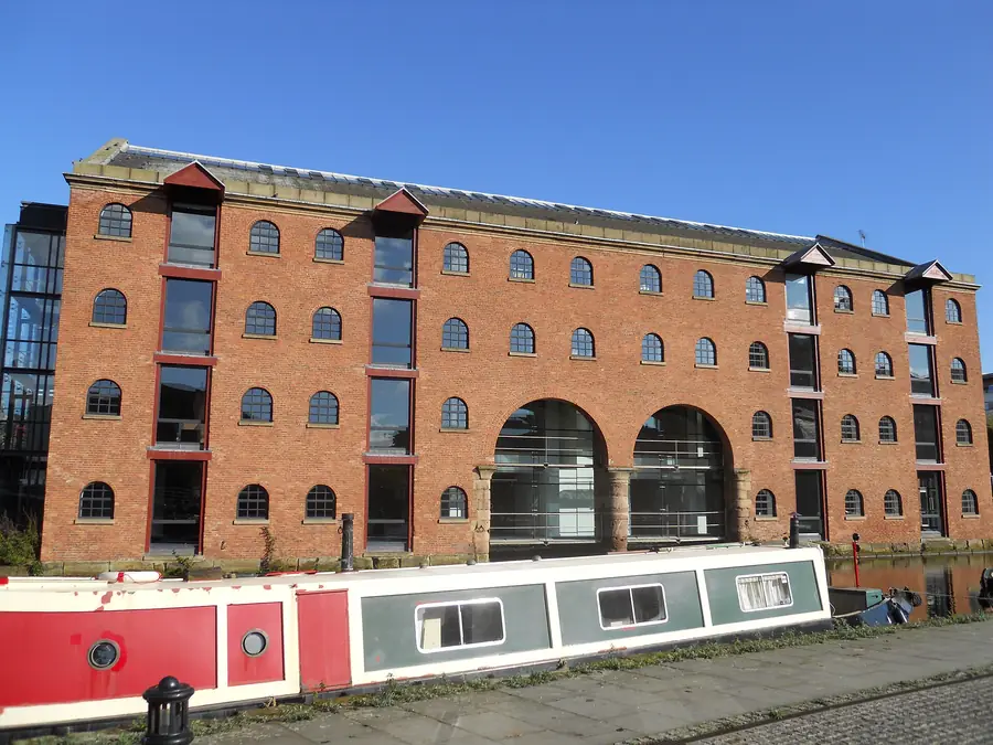 Merchants' Warehouse on the Bridgewater Canal basin in Castlefield, Manchester, with a narrowboat moored alongside